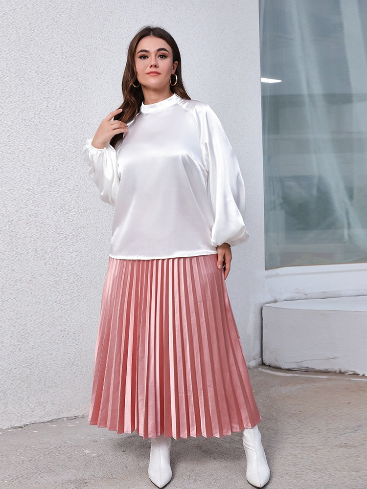 Conjunto Plus Size em duas peças de blusa branca de manga comprida e saia plissada rosa